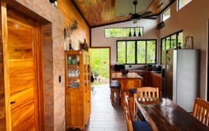 Interior of a warm, wooden kitchen with large windows and mountain scenery.