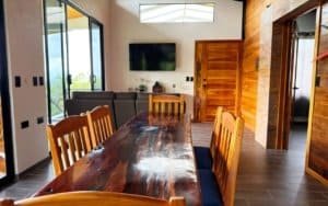 Spacious dining area with wooden table and mountain view windows.