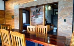 Interior of a rustic Costa Rican home with wooden furniture and mountain views.