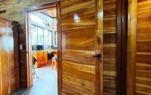 Warm wooden interior with door leading to kitchen and mountain views.