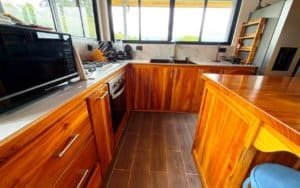 Kitchen with wooden cabinets, modern appliances, and mountain view through window.