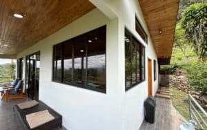 Contemporary Costa Rican house with large windows and mountain scenery in the background.
