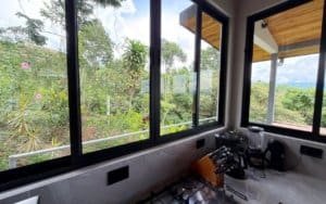 Kitchen with large windows overlooking lush greenery and mountains in Dominical.