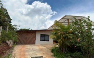 Contemporary house with mountain views, lush greenery, and clear sky in Dominical.