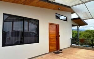 Contemporary Costa Rican home with wooden door and mountain views.