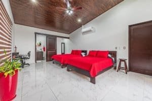 Spacious bedroom with red bedding and modern decor in a Dominical villa.