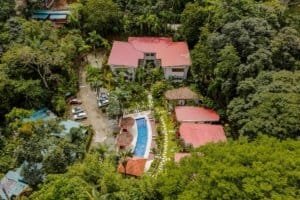 Aerial view of a private villa with pool surrounded by lush forest in Dominical.