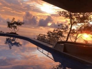 Stunning ocean view sunset with pool and tropical trees in Dominical, Costa Rica.