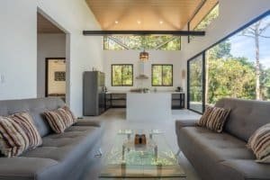 Dominical real estate living room with modern open-plan design and glass walls.