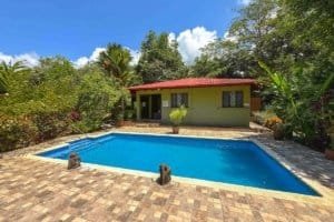 Beautiful jungle hotel with pool, surrounded by lush greenery in Dominical, Costa Rica.
