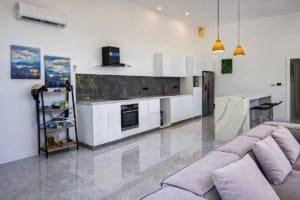 Modern kitchen and open living space with white cabinets and island in Dominical area.