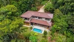 Luxury jungle villa with a pool and surrounding tropical rainforest.