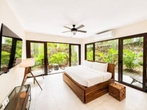 Bright bedroom with garden view, large windows, and resort amenities.