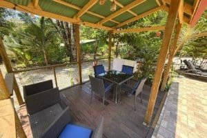 Covered outdoor deck with dining table, chairs, and lush jungle view in Dominical.
