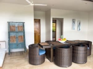 Modern dining area with wicker chairs and ocean view in Dominical, Costa Rica.
