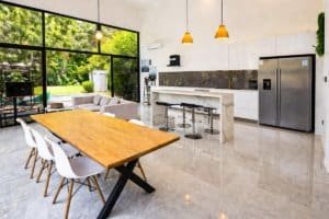 Modern kitchen and dining area with large glass doors to lush outdoor space.