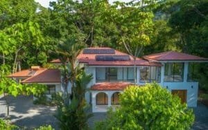 Dominical real estate tropical villa with pool and lush greenery.