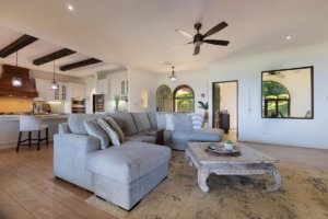 Spacious living room with modern furniture, ceiling fan, and ocean view.