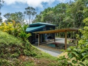 Dominical real estate: modern cabin with pool, covered patio and lush jungle surroundings.