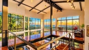 Panoramic sunset ocean view from a modern Costa Rica living room with large windows.