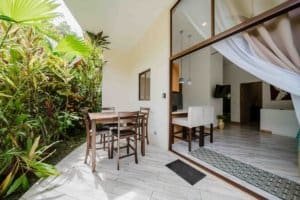 Furnished Costa Rican villa with outdoor dining and lush garden view.