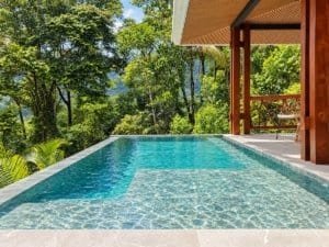 Swimming pool with clear water and surrounding tropical trees in Dominical Costa Rica.