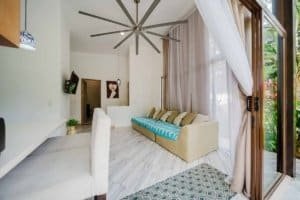 Bright living room with large windows, white walls, and tropical decor in Dominical.