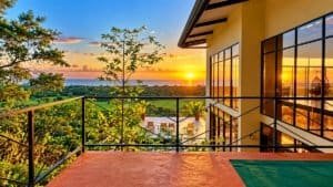 Dominical Costa Rica sunset view from terrace with glass railing and modern home.