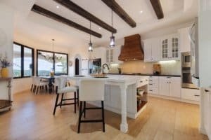 Modern kitchen with island, white cabinets, and ocean view in Dominical.