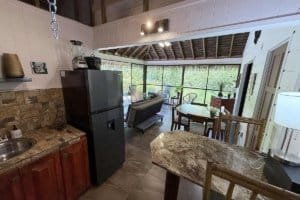Interior of a natural jungle home with a pool view, kitchen, and dining area in Costa Rica.