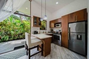 Modern kitchen with wooden cabinets and garden view in Dominical.