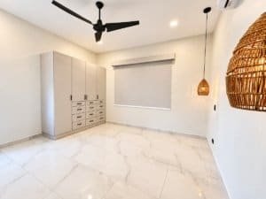 Bright bedroom with large tiled floor, built-in wardrobe and hanging wicker light.