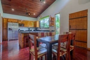 Bright kitchen with wooden cabinets, stainless steel appliances, and dining table in Costa Rica.
