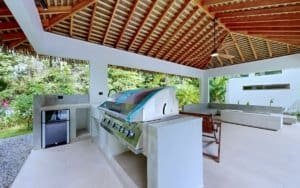 Outdoor bar area with built-in grill under a wooden roof in Costa Rica.