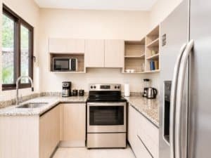 Contemporary kitchen with granite countertops and stainless steel appliances in Dominical.