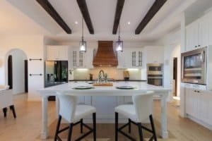 Modern kitchen with white cabinets, island, and mountain view in Dominical.