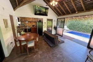 Cozy jungle home with private pool, open living area, and outdoor view.