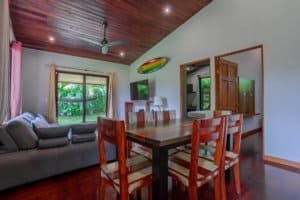 Bright living and dining area in Dominical real estate with wooden ceiling and large windows.