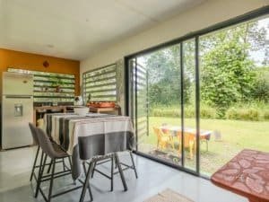 Bright living space with large glass doors overlooking lush garden.