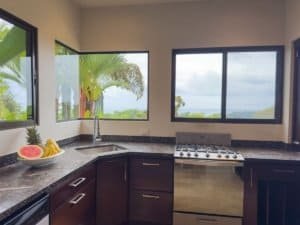Kitchen with large windows showing ocean and tropical trees in Dominical.
