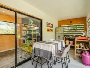 Interior of a Costa Rican home with dining table, kitchen, and colorful decor.