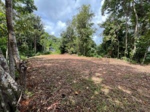 Ridge top land with panoramic forest and dirt clearing in Costa Rica.