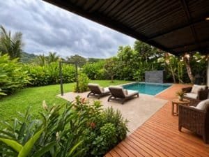 Beautiful tropical home with pool, lounge chairs, and lush garden in Dominical.