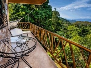 Balcony with ocean view, tropical rainforest, and lush greenery in Dominical.