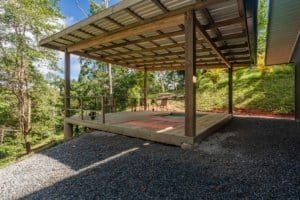 Creekside wooden deck with pergola and forest backdrop in Costa Rica.