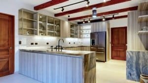 Modern tropical kitchen with island, dark wood beams, stainless steel appliances and ample cabinetry.