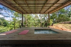 Creekside covered deck with a hot tub, lounge chairs and forest view in Dominical, Costa Rica.