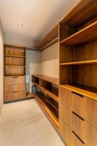 Dominical real estate walk-in closet with wooden shelves and drawers.