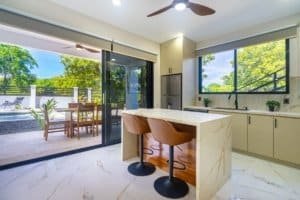 Dominical condo with modern kitchen island, breakfast bar, and patio access to outdoor living.