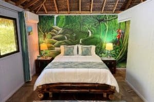 Cozy bedroom with jungle mural, natural decor, and tropical ambiance.